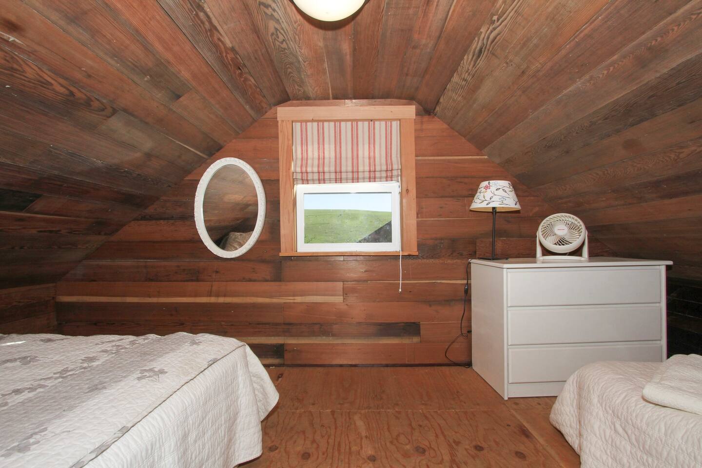 The sleeping loft has a queen-sized bed, a twin bed, and cute little window. So cozy.
