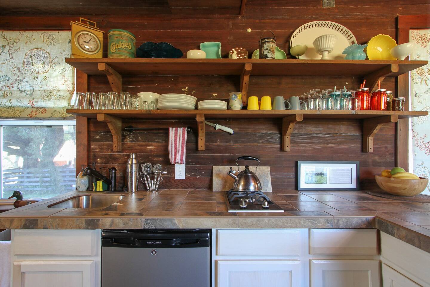 The kitchenelle has a dorm sized refrigerator, small sink, two burner stove, toaster oven, Keurig coffee maker, and outside there is a gas grill.