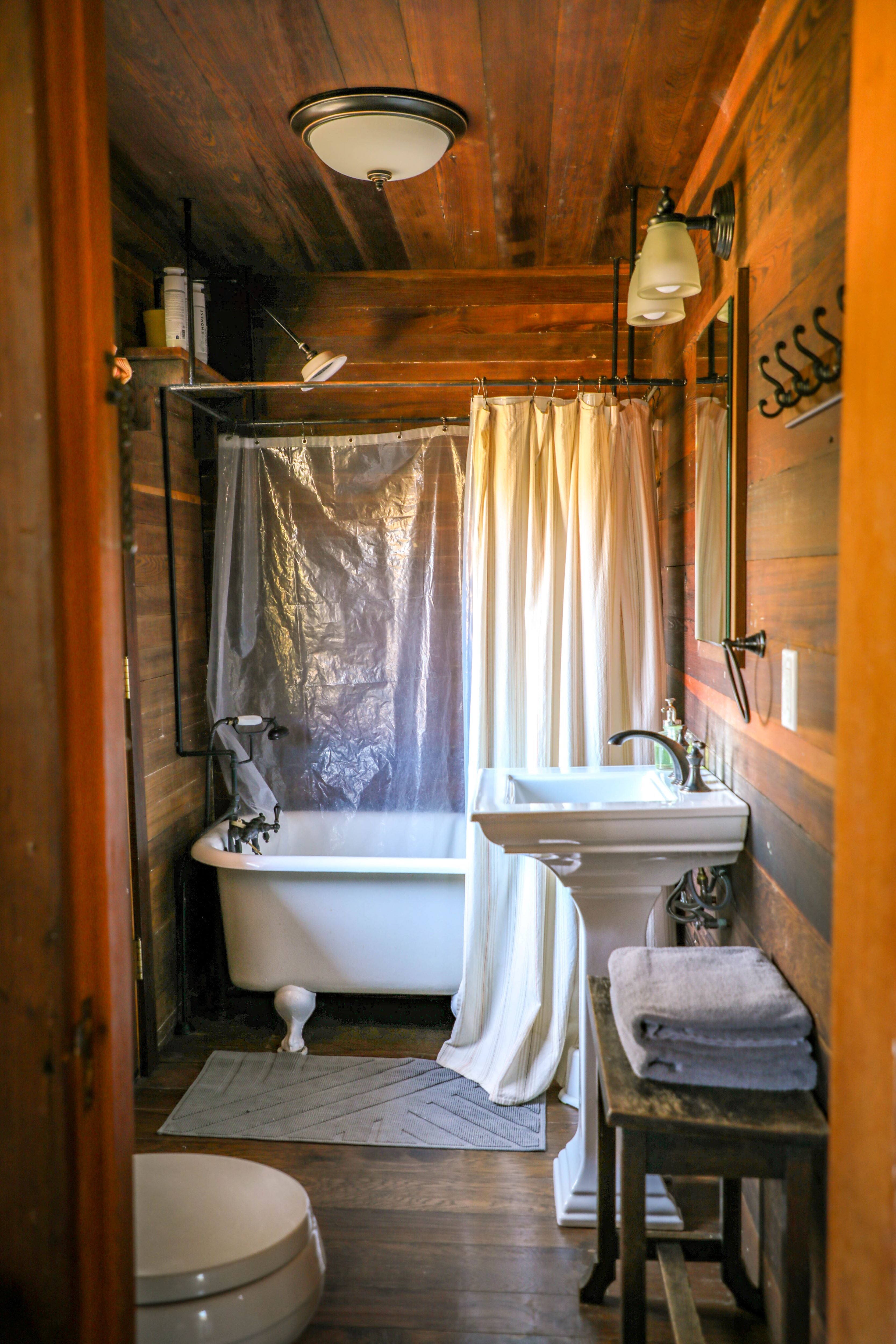 The bathroom has an antique clawfoot tub/shower combo. 