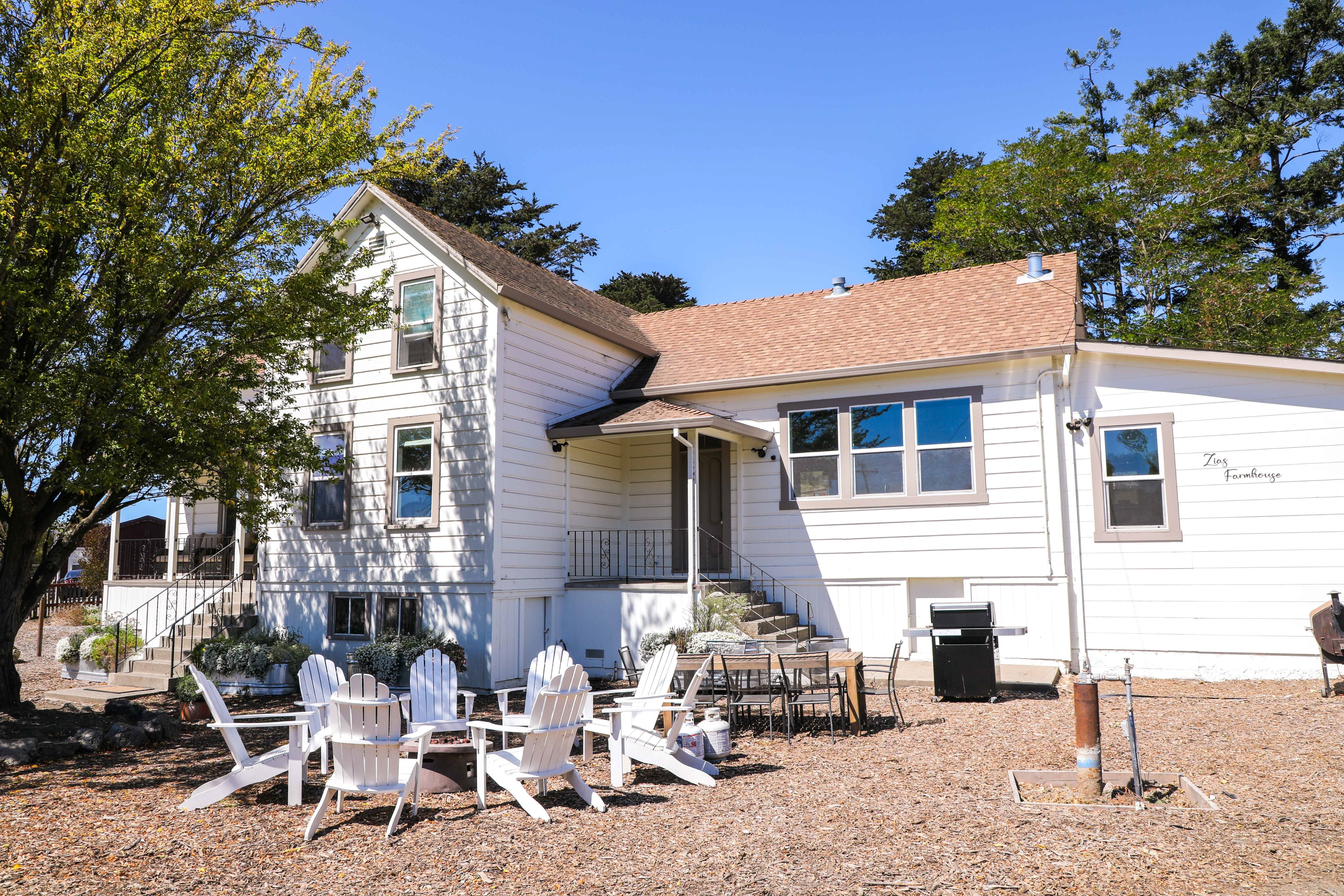 The front yard has a gas firepit, adirondack chairs, an outdoor dining table, and a gas BBQ. 