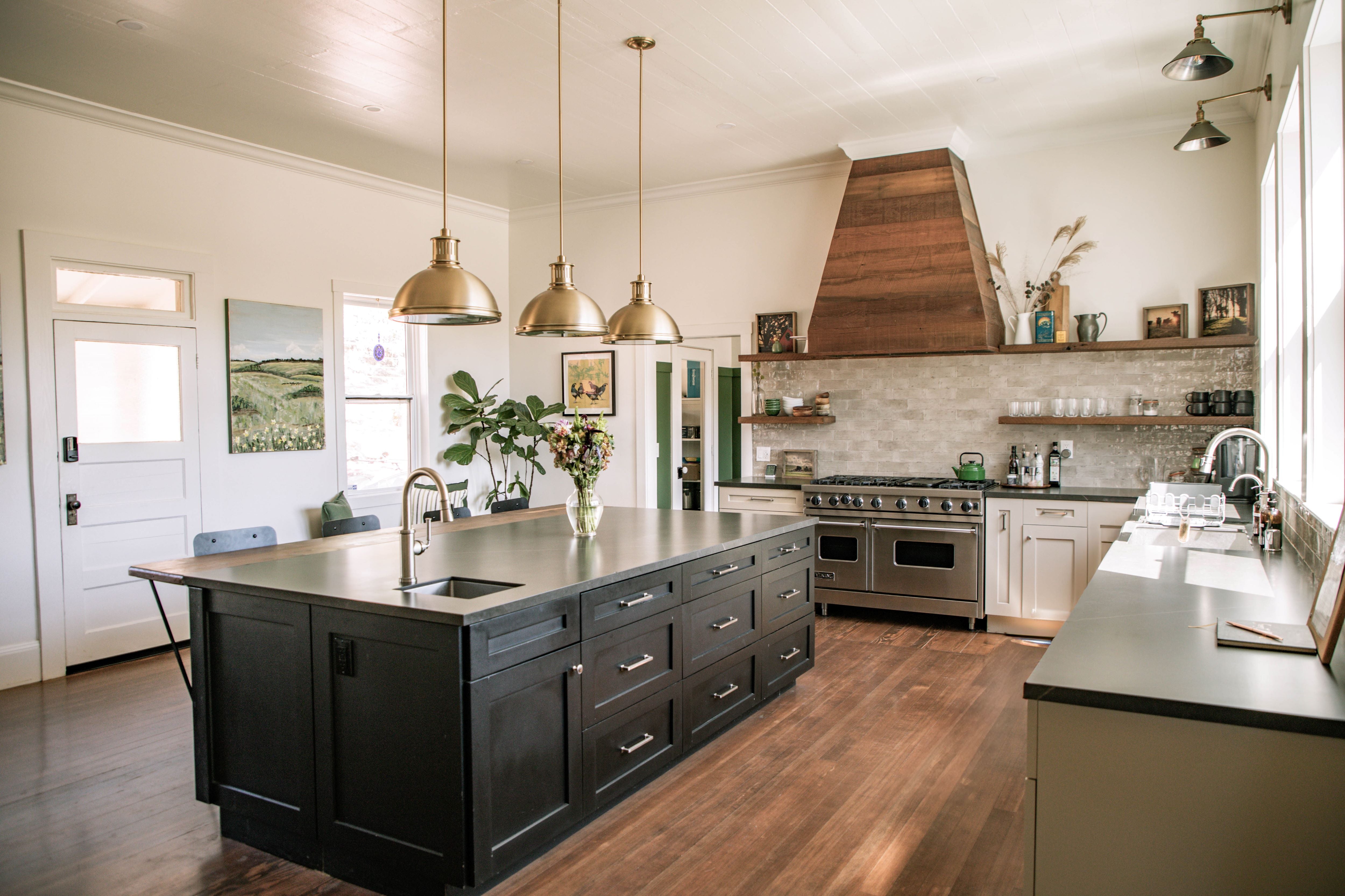 The Chef's kitchen has a 48-inch Viking gas range, double ovens, two dishwahsers, two sinks, a built-in refrigerator and freezer, and a large island with seating. There is a gas grill outside. 