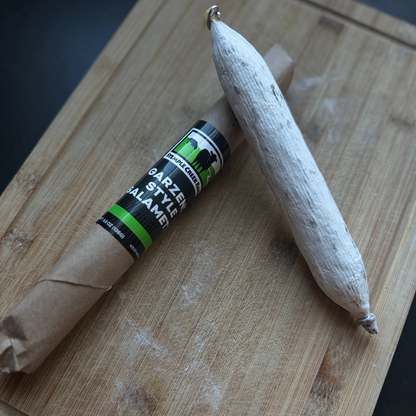Cured meat with a label on a wooden cutting board